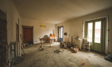 Wide view of a sunny room under renovation with construction materials and tools present, ideal for home improvement concepts.